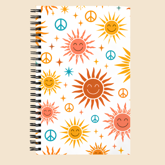 Libreta vintage con espiral y diseño hippie de soles retro sonrientes y símbolos de paz en colores cálidos.