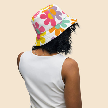 Persona llevando gorro bucket unisex reversible con diseño All Over Print de inspiración retro y colores arcoíris.