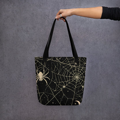 Bolsa de tela negra con estampado vintage de telarañas, araña, luna y estrellas llevada por una persona