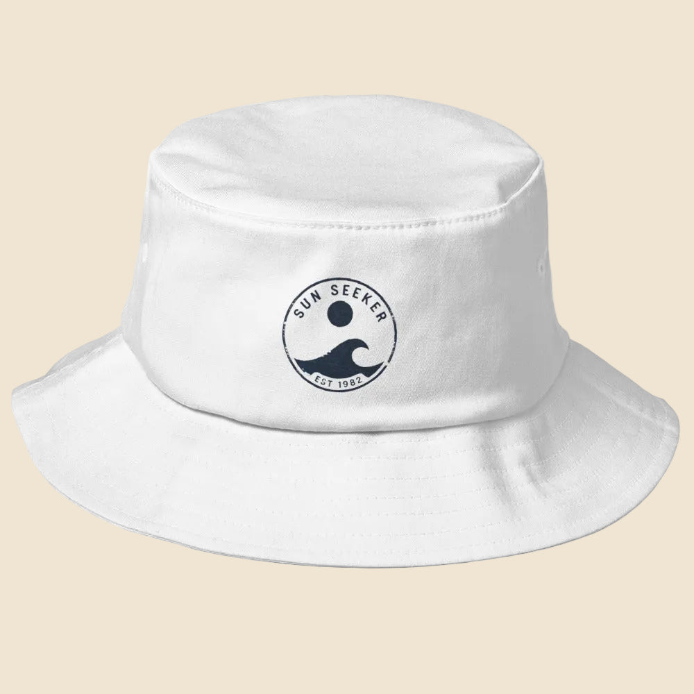 Gorro de pescador blanco sobre fondo neutro mostrando el diseño urbano Sun Seeker.