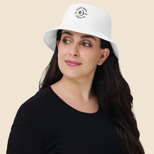 Mujer vistiendo gorro bucket color blanco de estilo urbano con emblema skater clásico.