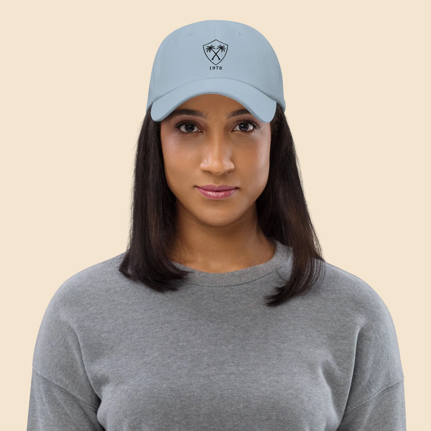 Mujer vistiendo gorra dad hat azul claro de estética coastal vintage con bordado frontal de palmeras.
