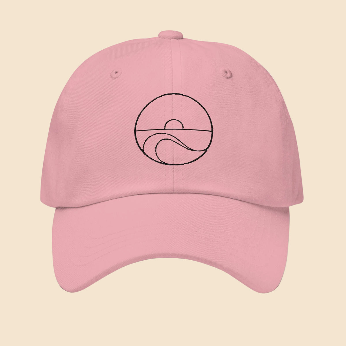 Gorra dad hat de sarga de algodón en color rosa con diseño minimalista bordado de sol y olas del mar en color negro.