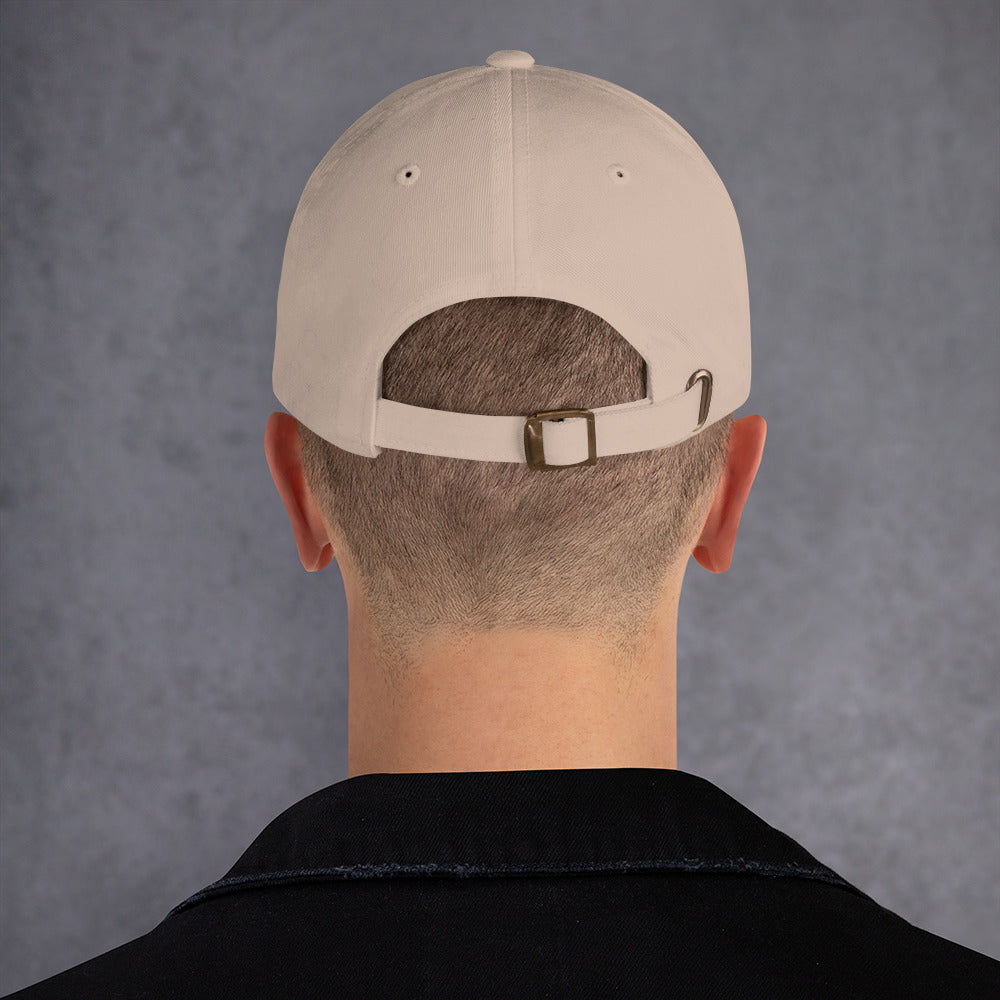 Hombre de espaldas con la gorra dad hat color piedra mostrando la hebilla metálica envejecida.
