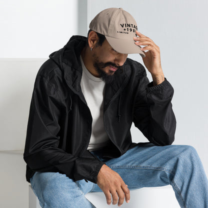 Persona sentada en exterior con gorra beige Vintage 1986 y ropa casual