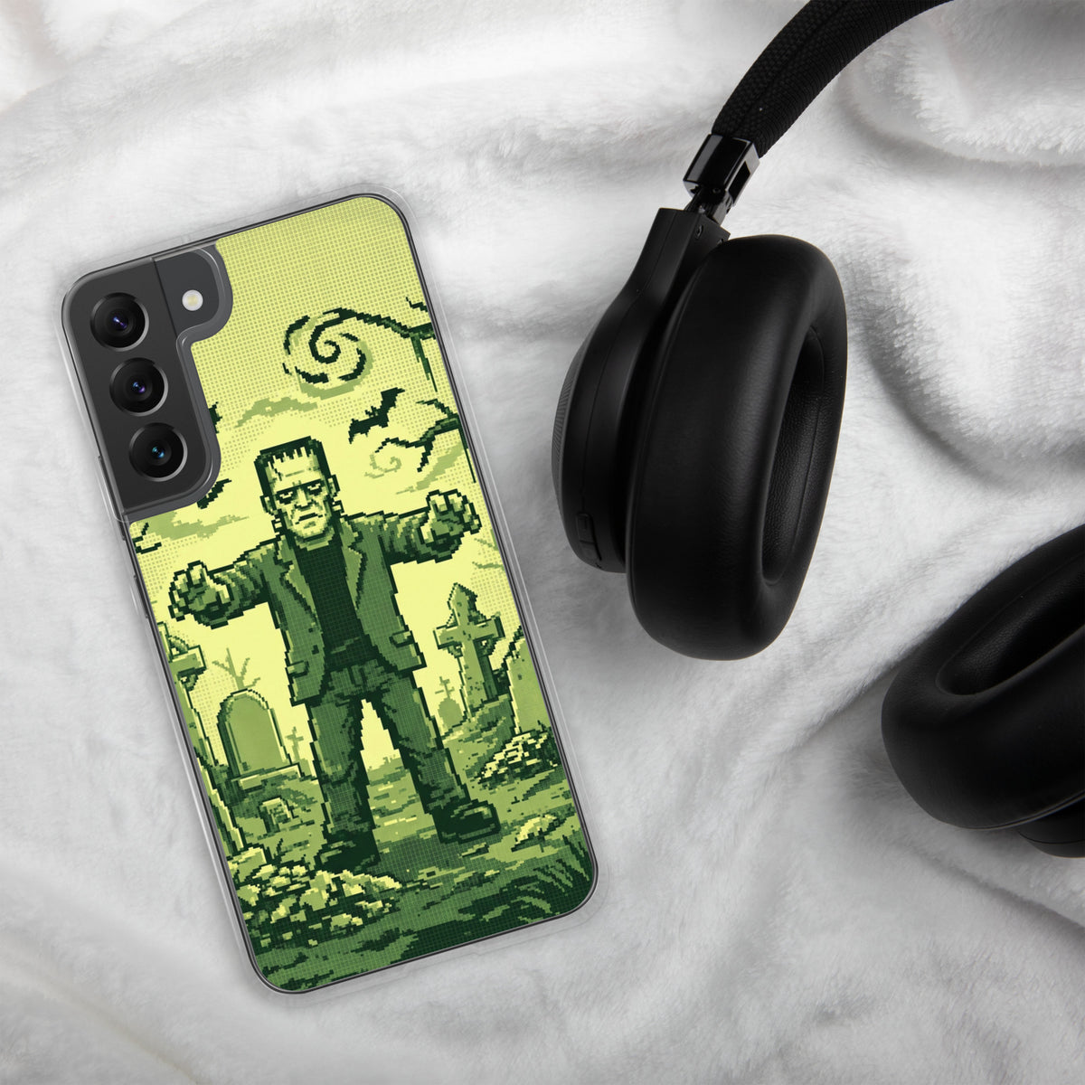 Funda transparente para Samsung® con Frankenstein en pixel art verde, mostrada junto a unos auriculares.