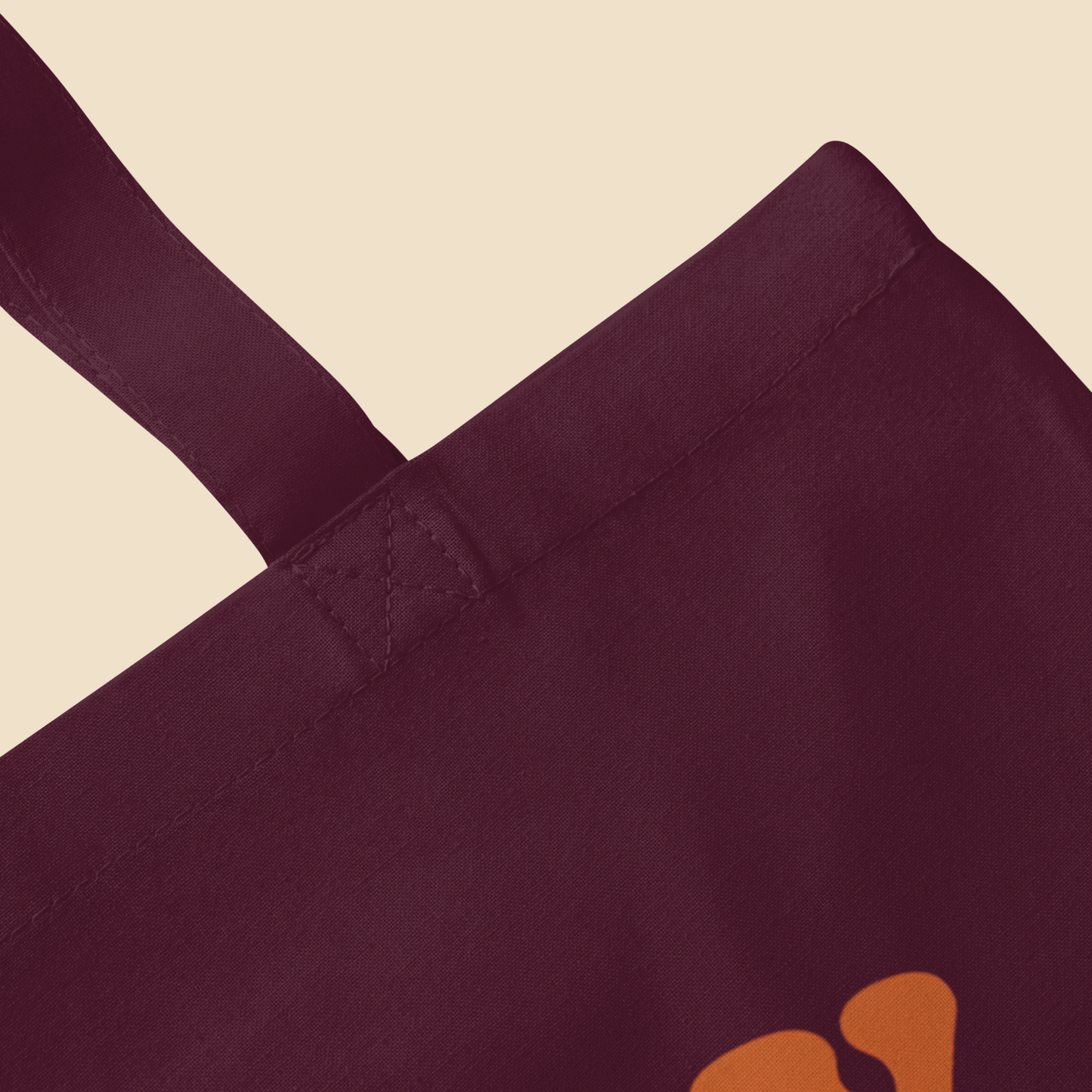 Detalle superior y asa de bolsa de tela color burgundy de estilo urbano.