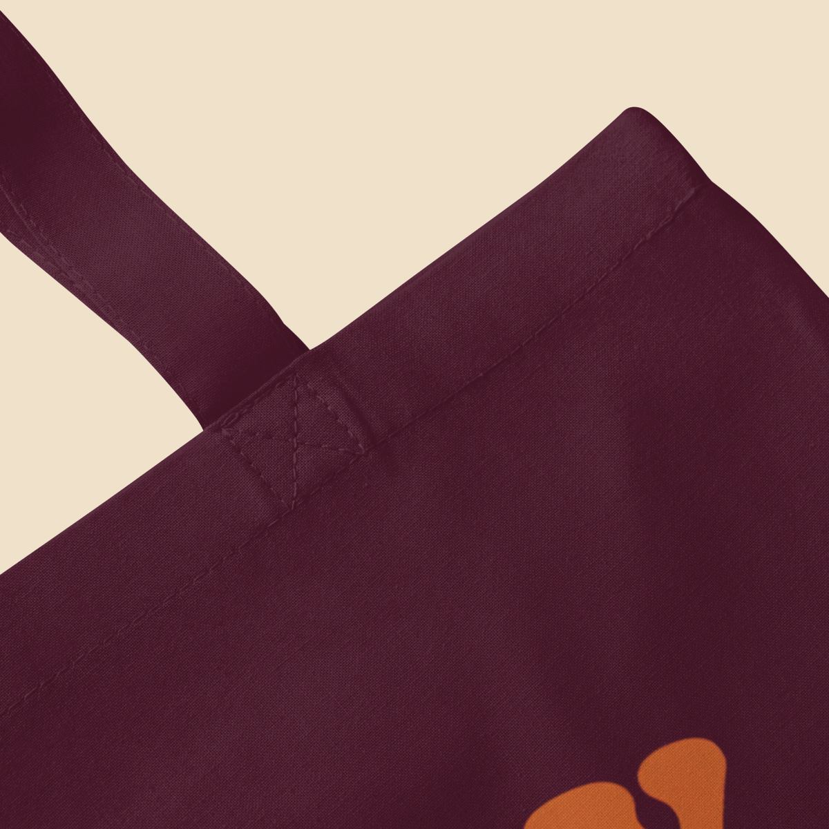 Detalle superior y asa de bolsa de tela color burgundy de estilo urbano.