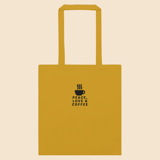 Tote bag de algodón color amarillo mostaza con estampado de taza de café en color negro.