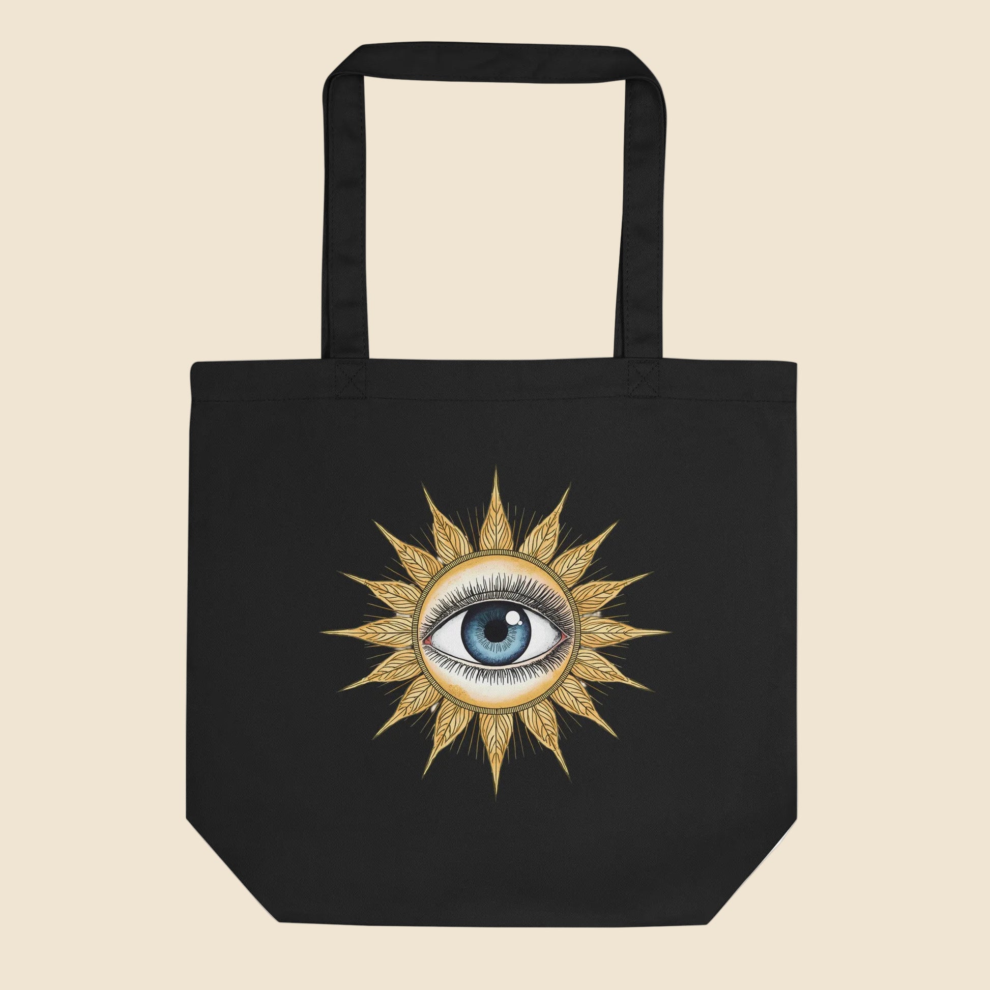 Bolsa de tela tote bag negra de algodón orgánico con diseño frontal retro de sol dorado y ojo místico.