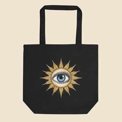 Bolsa de tela tote bag negra de algodón orgánico con diseño frontal retro de sol dorado y ojo místico.
