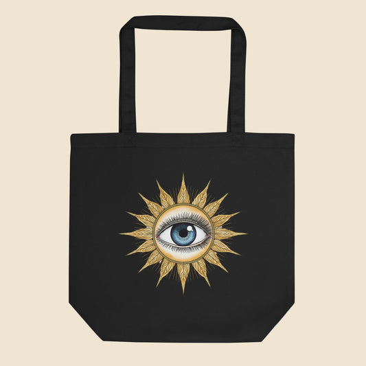 Bolsa de tela tote bag negra de algodón orgánico con diseño frontal retro de sol dorado y ojo místico.