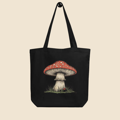 Bolsa de tela tote bag negra de algodón orgánico con diseño frontal de ilustración botánica de seta amanita.