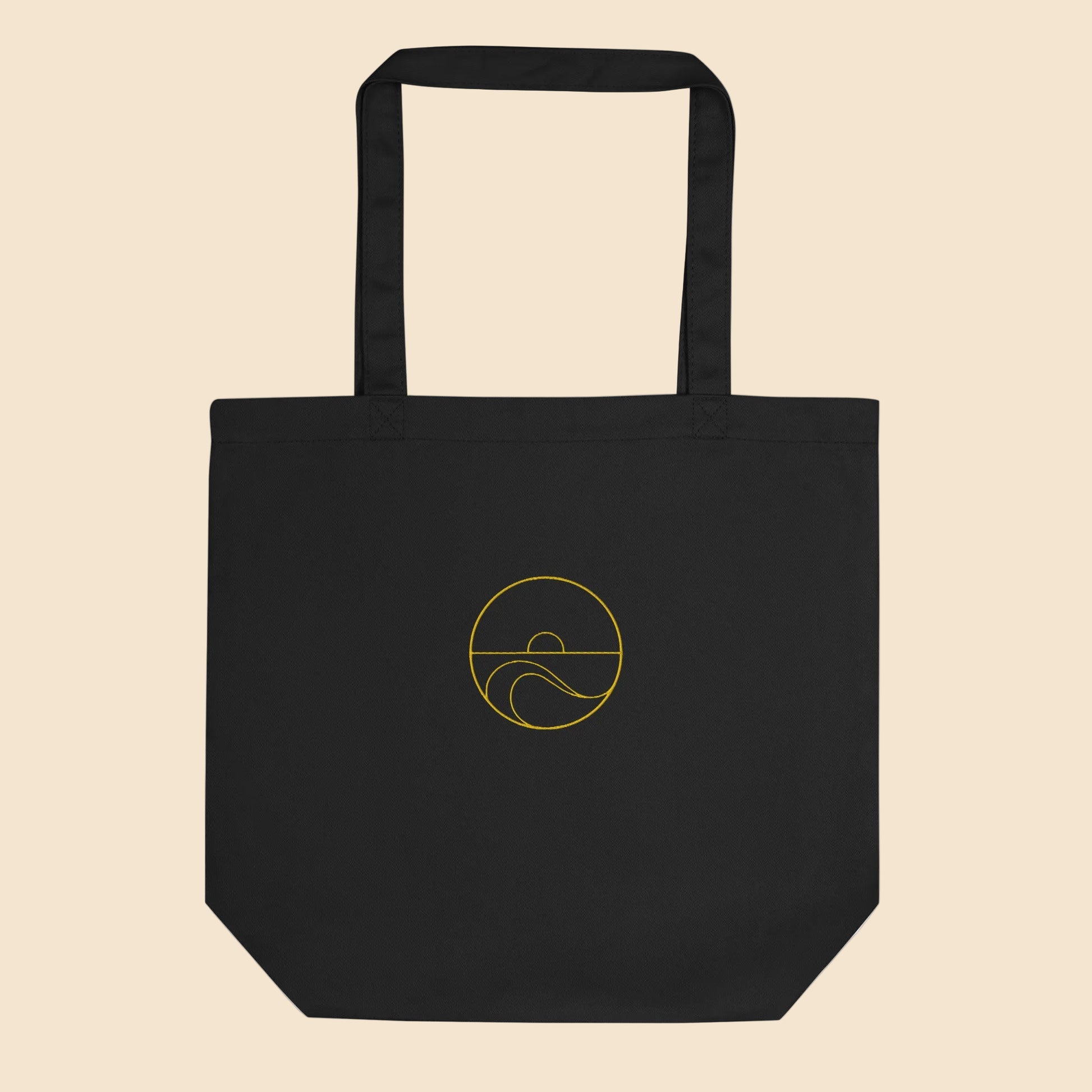 Ecobolsa de algodón orgánico color negro con estampado circular dorado de sol y olas del mar.