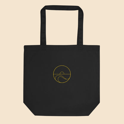 Ecobolsa de algodón orgánico color negro con estampado circular dorado de sol y olas del mar.