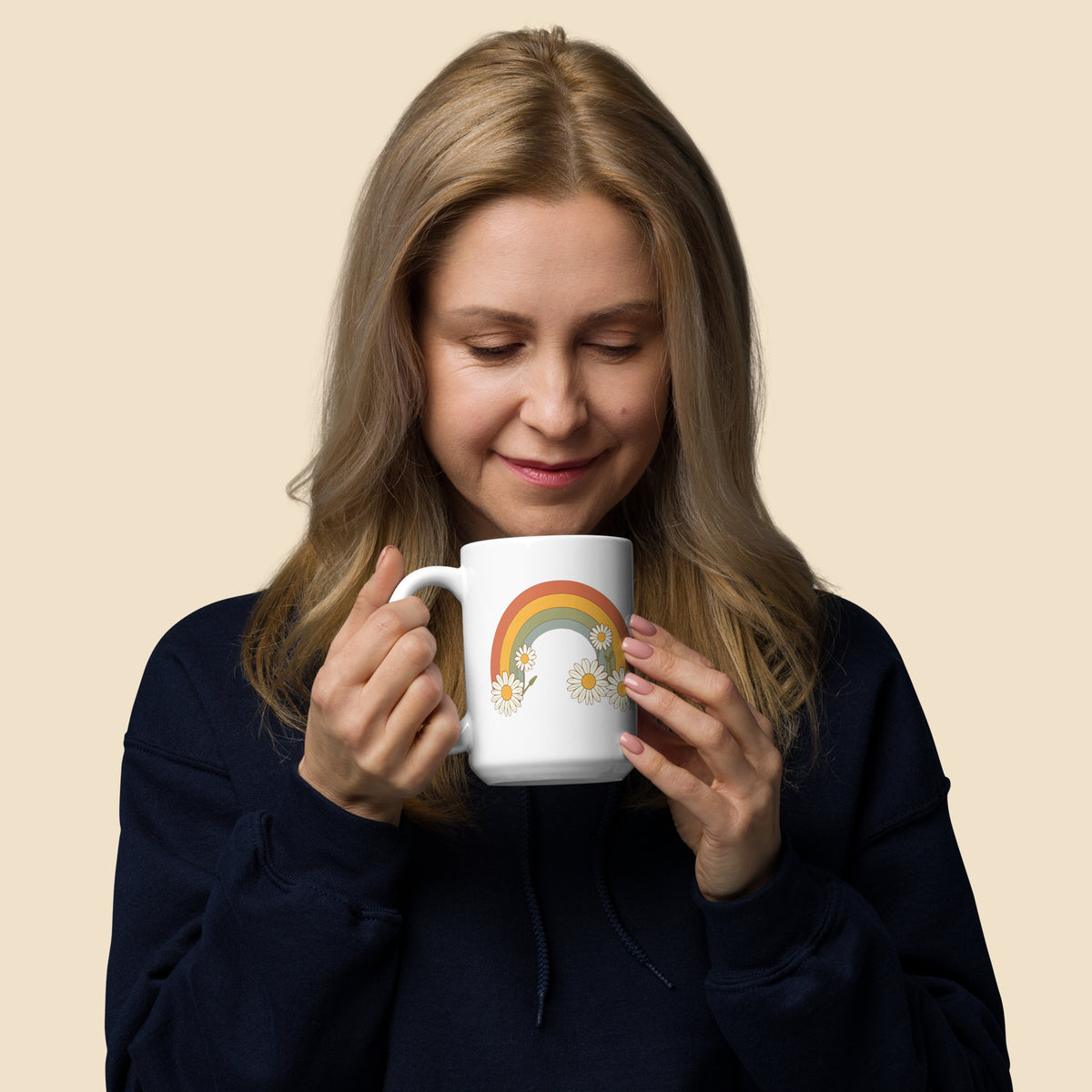 Mujer sosteniendo en sus manos una taza blanca con diseños arcoiris LGTBIQ+