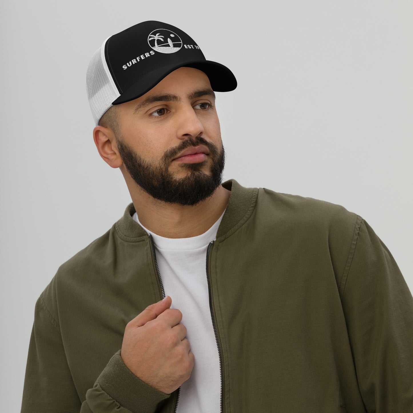 Hombre vistiendo gorra de rejilla en tonos marrón y caqui de estética costera de los años 80.