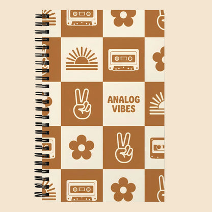 Libreta vintage con espiral y diseño Analog Vibes con casetes, flores, símbolos de paz y estética retro años 70.