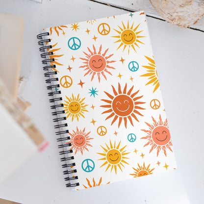  libreta retro con diseño de soles psicodélicos y símbolos de paz.