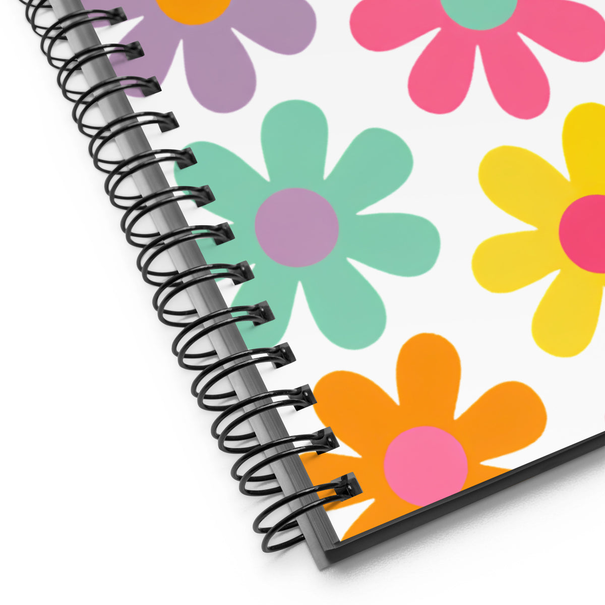 Detalle de encuadernación en espiral y diseño floral vintage de libreta creativa.