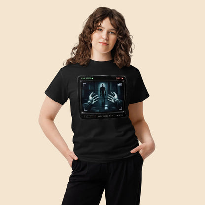 Mujer con camiseta negra de terror retro con diseño de cámara de vigilancia y estética VHS