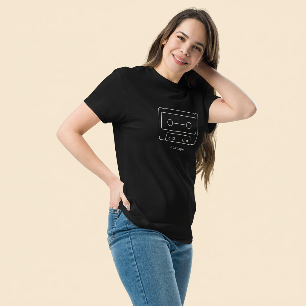 Persona vistiendo camiseta negra vintage con ilustración de cassette clásico.