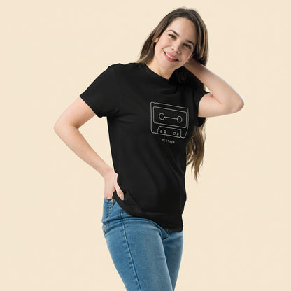 Persona vistiendo camiseta negra vintage con ilustración de cassette clásico.