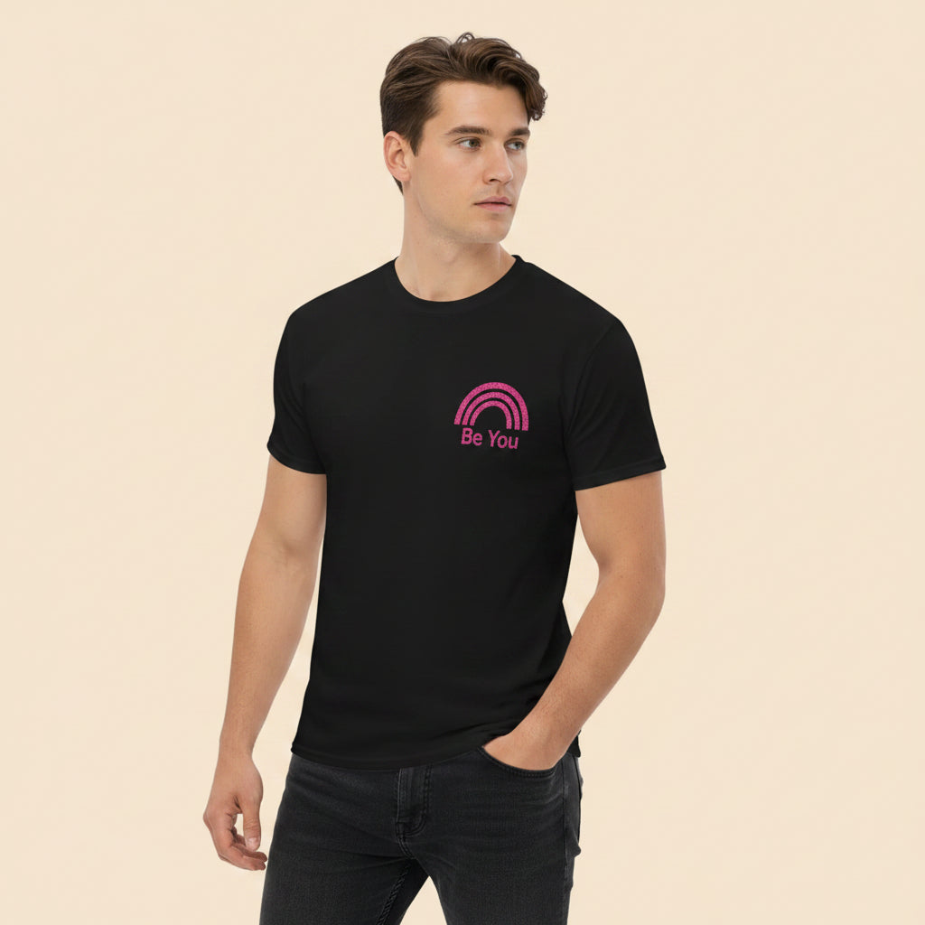 Persona vistiendo camiseta negra con gráfico Pride minimalista y mensaje Be You.