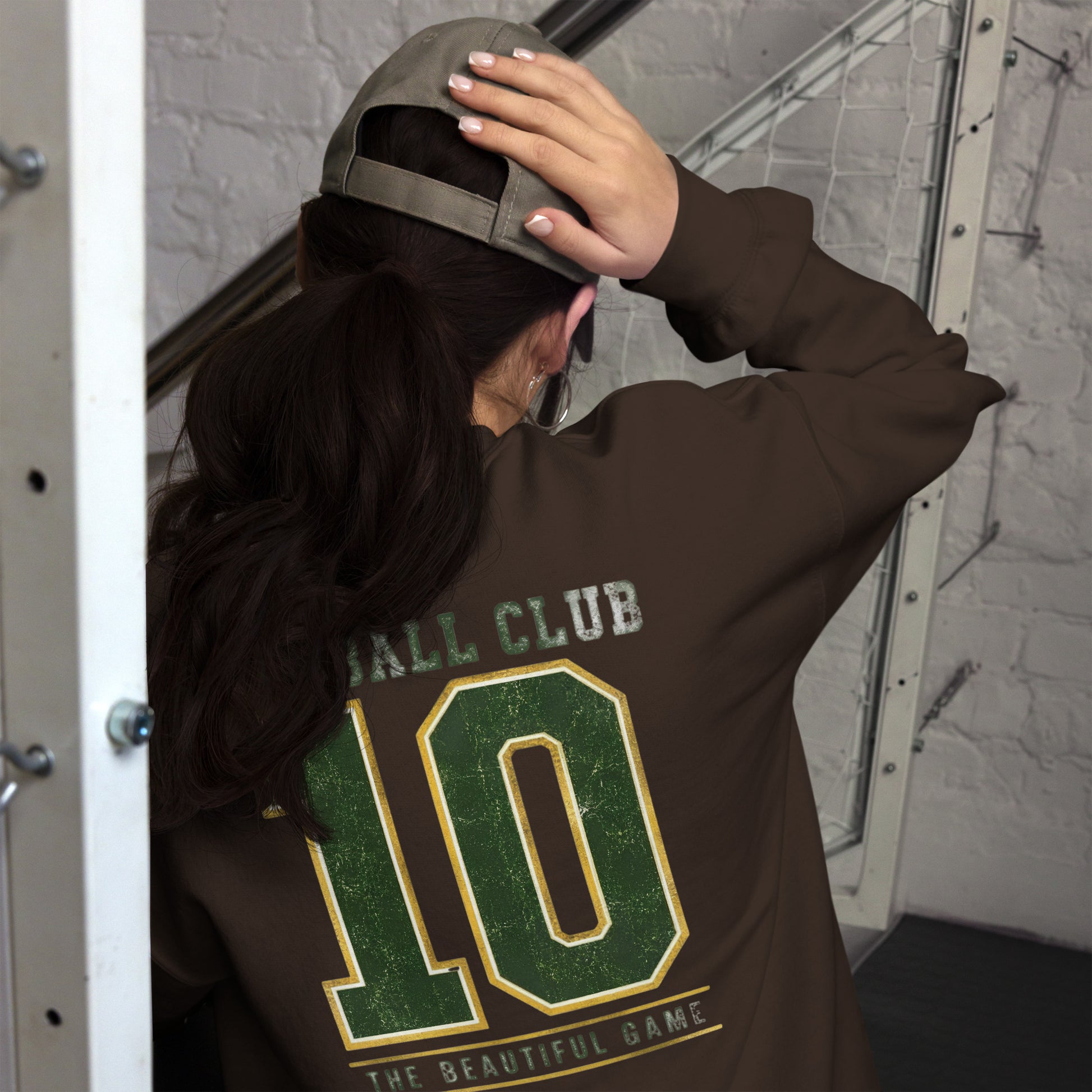 Mujer luciendo sudadera marrón chocolate de estilo streetwear con número 10 en la espalda.
