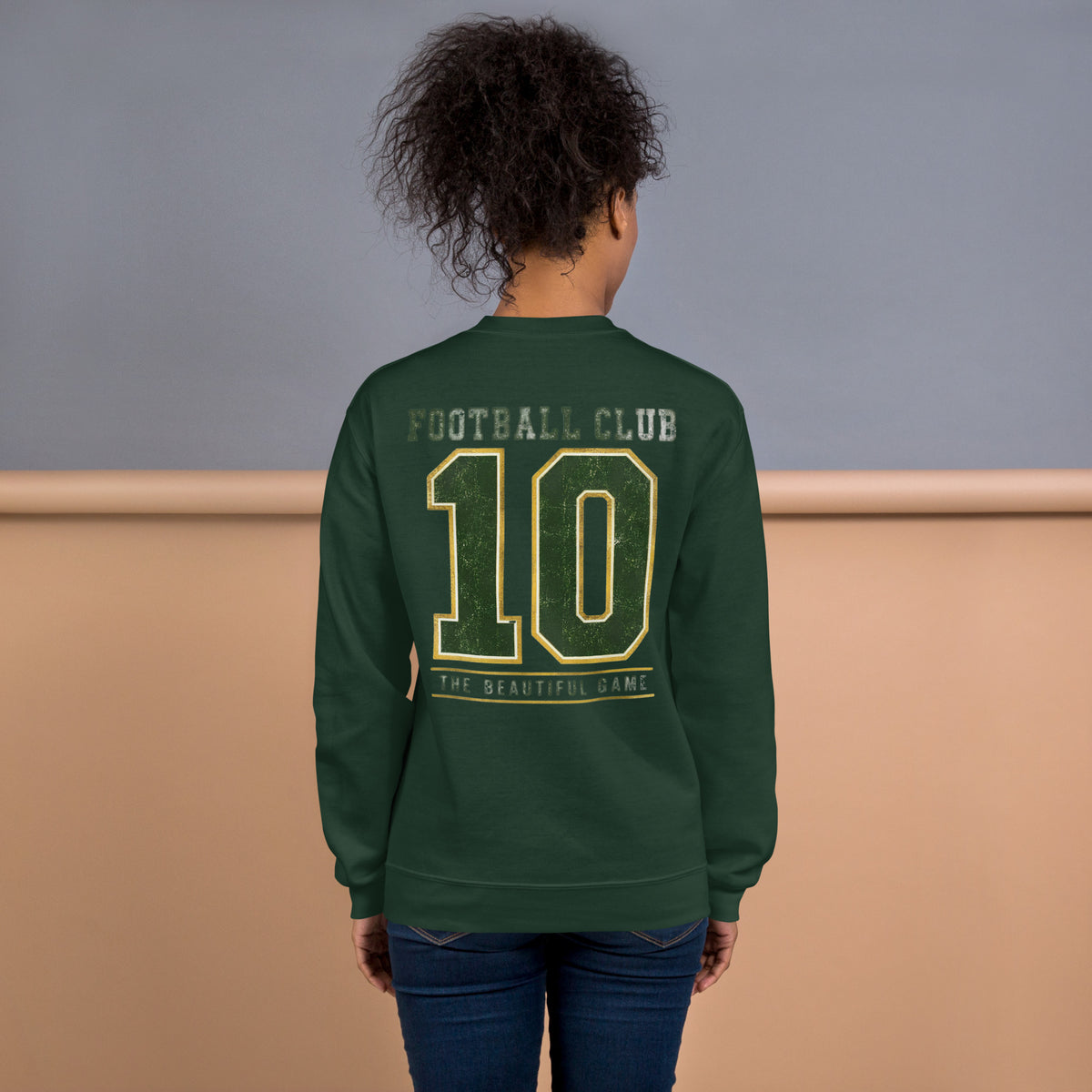 Mujer de espaldas vistiendo sudadera verde bosque con diseño universitario clásico.