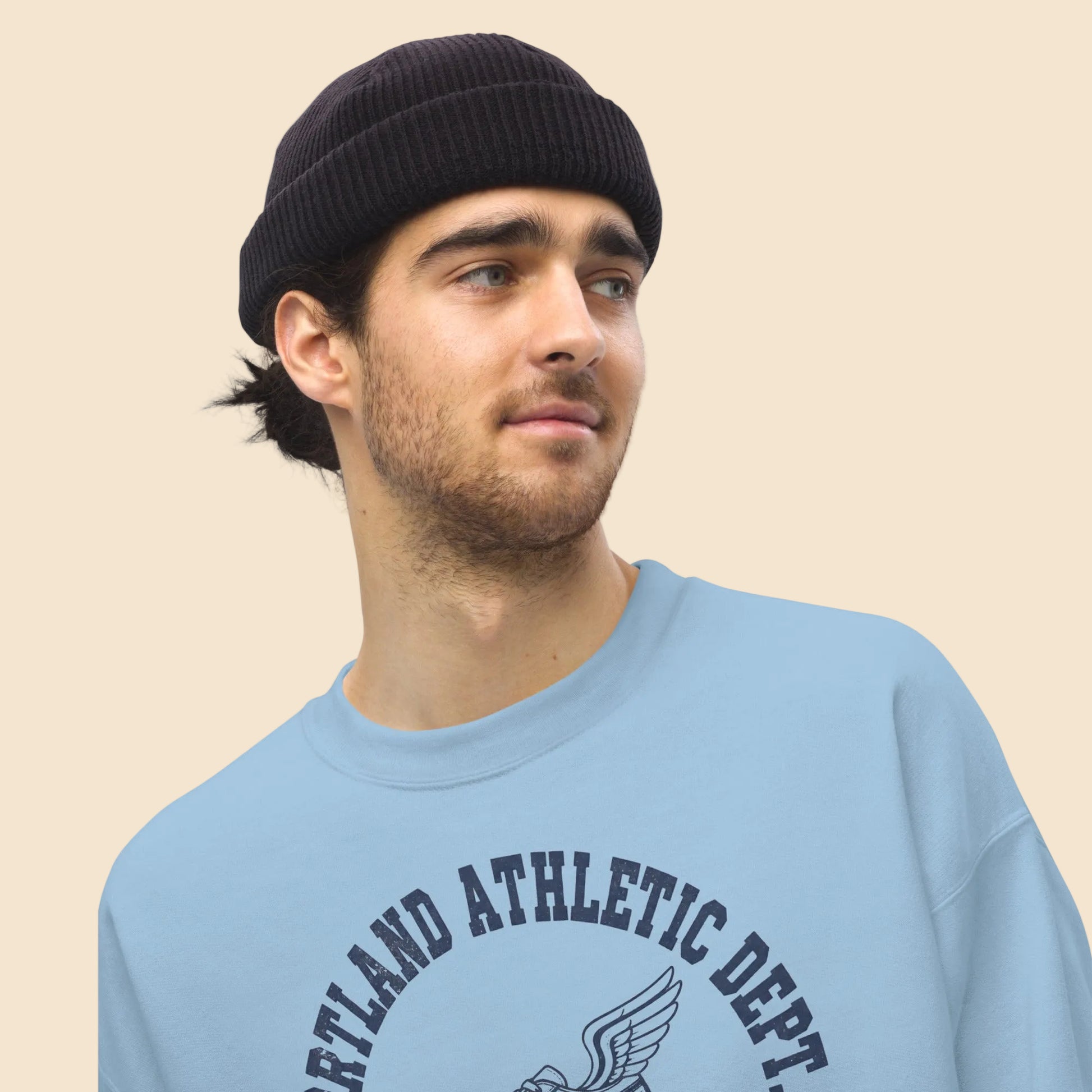 Hombre joven con gorro vistiendo sudadera deportiva vintage azul claro.