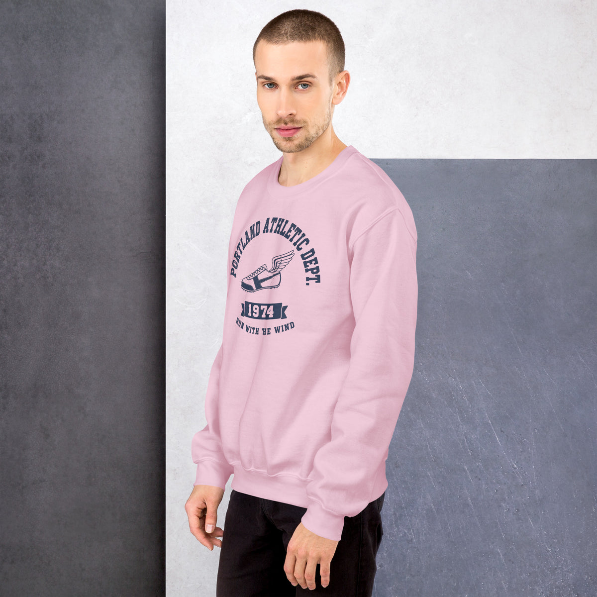 Hombre vistiendo sudadera rosa pastel con ilustración retro de zapatilla alada.
