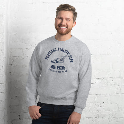  Hombre sonriendo con sudadera gris y diseño clásico de atletismo.
