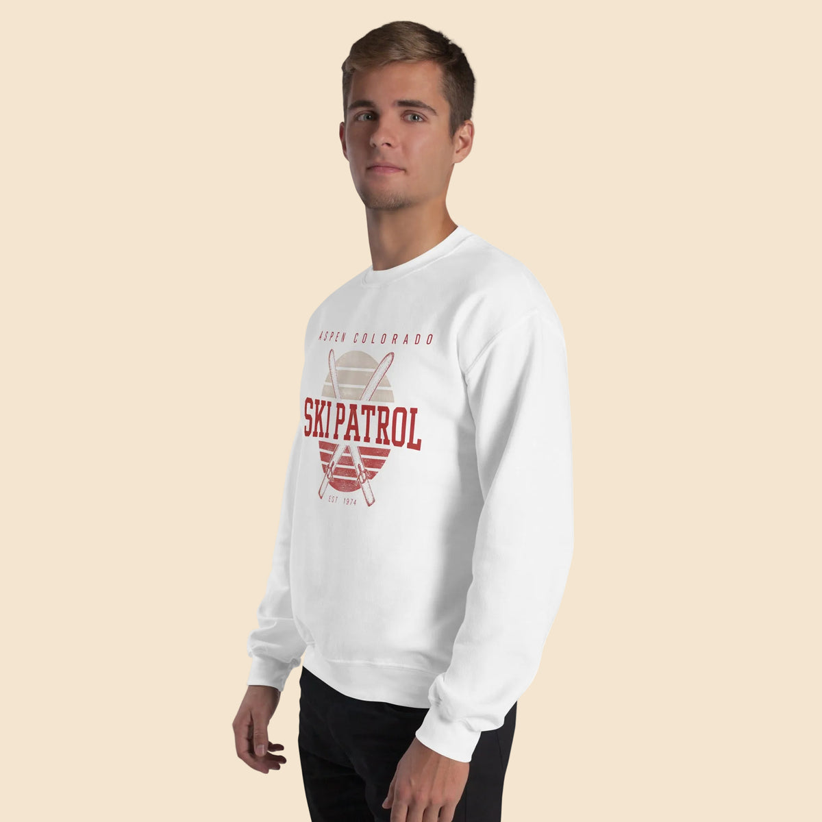 Hombre vistiendo sudadera unisex blanca de estilo vintage con gráfico frontal Aspen Ski Patrol.