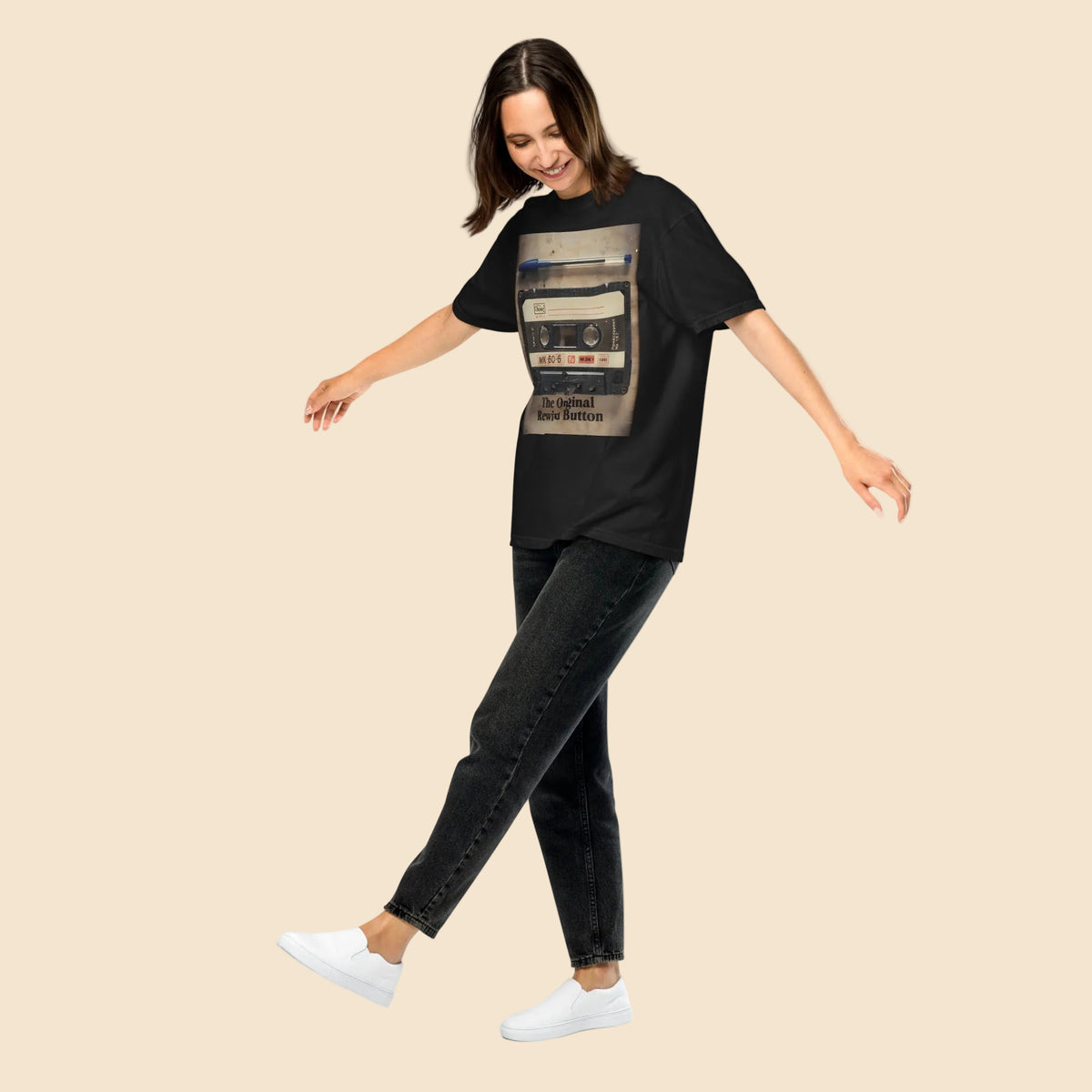 Mujer de cuerpo entero luciendo una camiseta negra de estilo retro con diseño nostalgico de los años 80 y corte holgado.