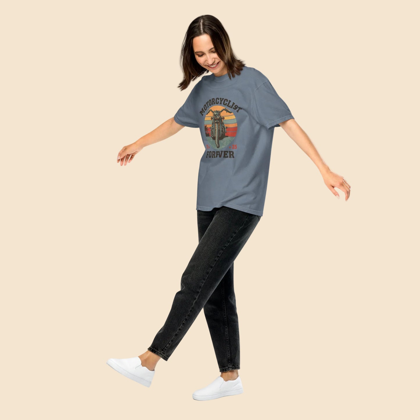 Mujer caminando con estilo casual urbano llevando una camiseta premium holgada con diseño de moto clasica.
