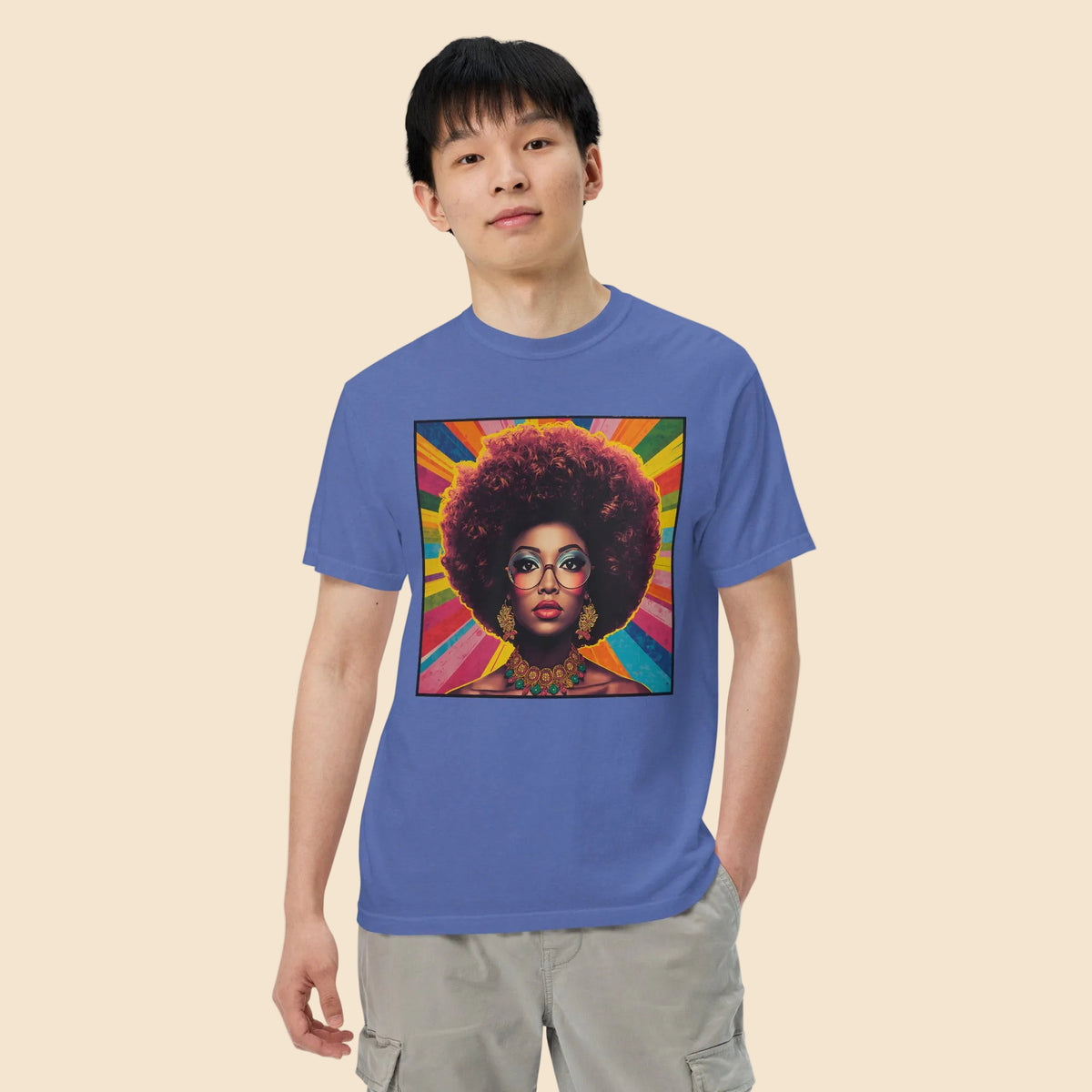 Hombre con camiseta azul lavado vintage mostrando un vibrante estampado retro de estilo soul y funk.
