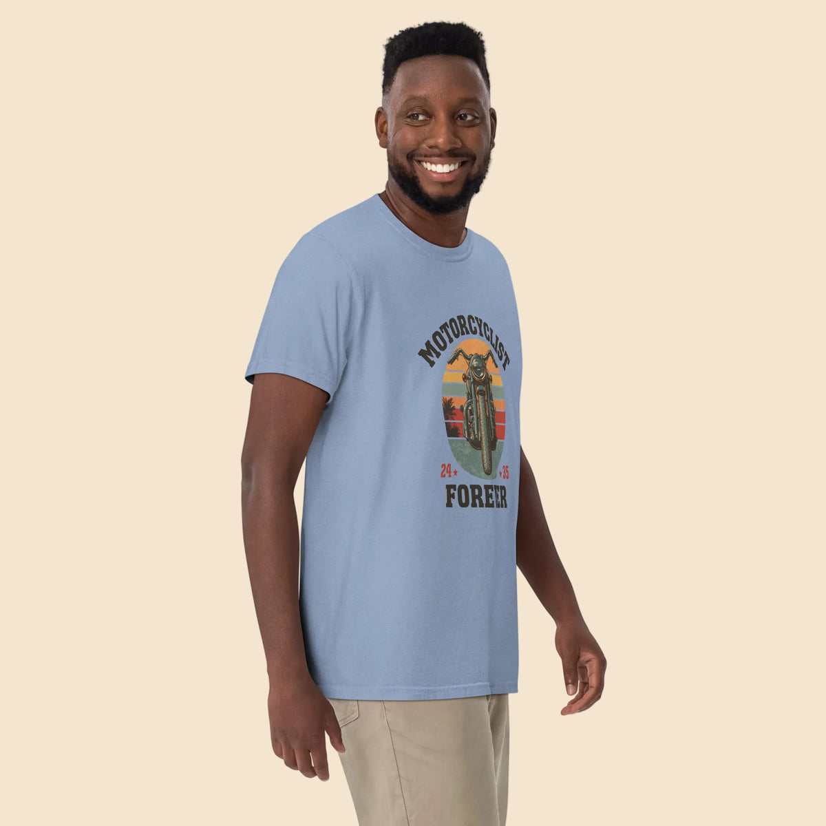 Hombre sonriendo con camiseta azul oscuro desgastado de estilo vintage Motorcyclist Forever.