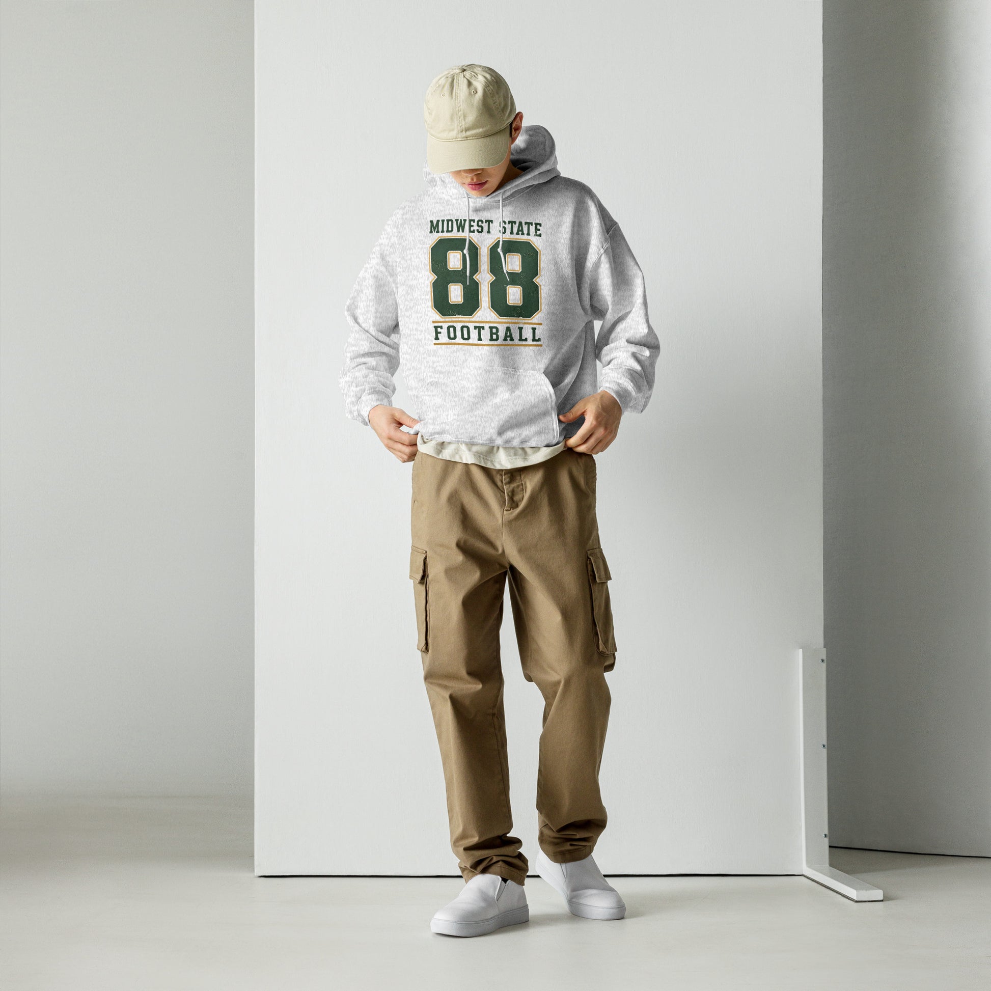 Hombre con pantalón cargo y sudadera universitaria gris de estilo retro.