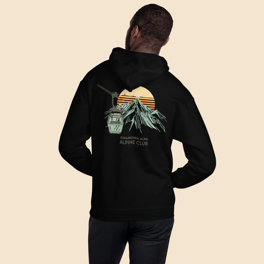Hombre de espaldas vistiendo sudadera negra con estampado vintage de montaña y teleférico.