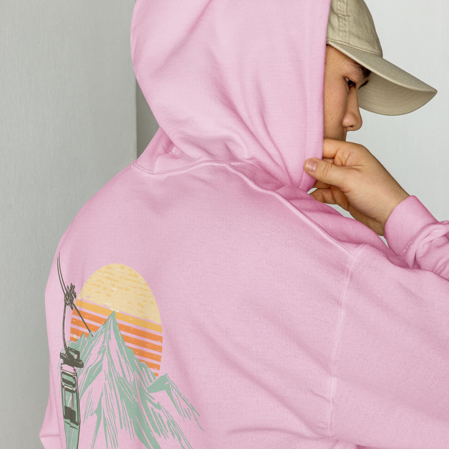 Detalle de capucha y estampado retro de invierno en sudadera color rosa pastel.