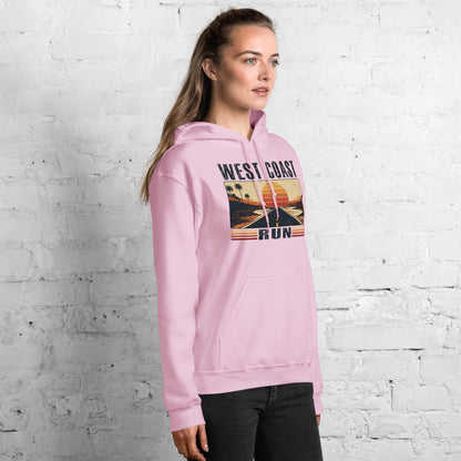 Mujer de perfil con sudadera rosa pastel y diseño retro de carretera al atardecer.
