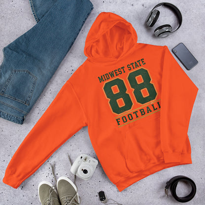 Sudadera con capucha naranja doblada junto a zapatillas y accesorios urbanos.