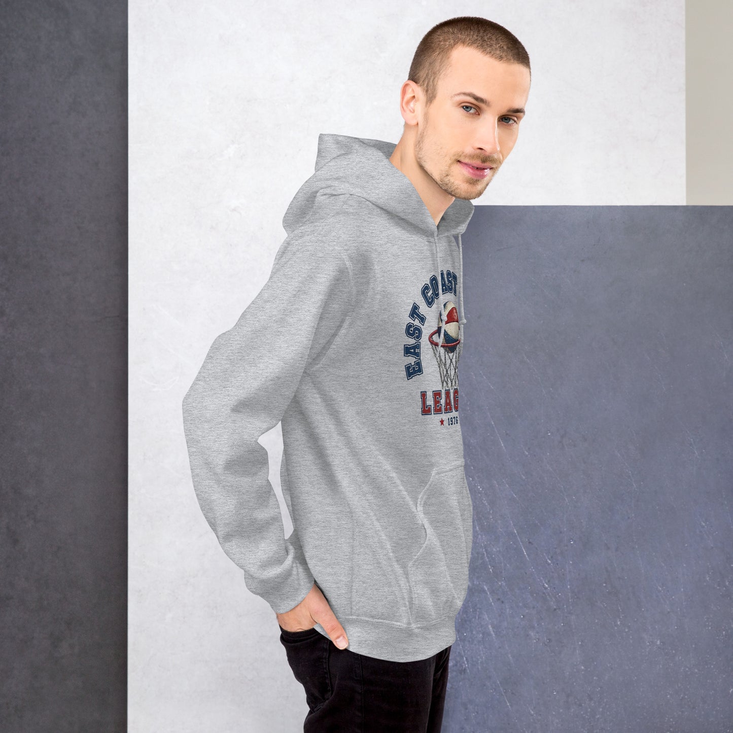 Modelo masculino luciendo sudadera con capucha gris de estilo deportivo varsity.
