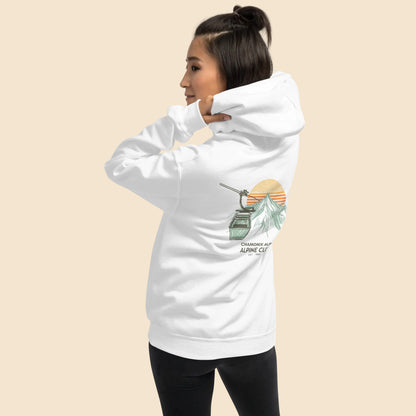 Mujer de espaldas con sudadera blanca y diseño ilustrado de los Alpes en los años 70.
