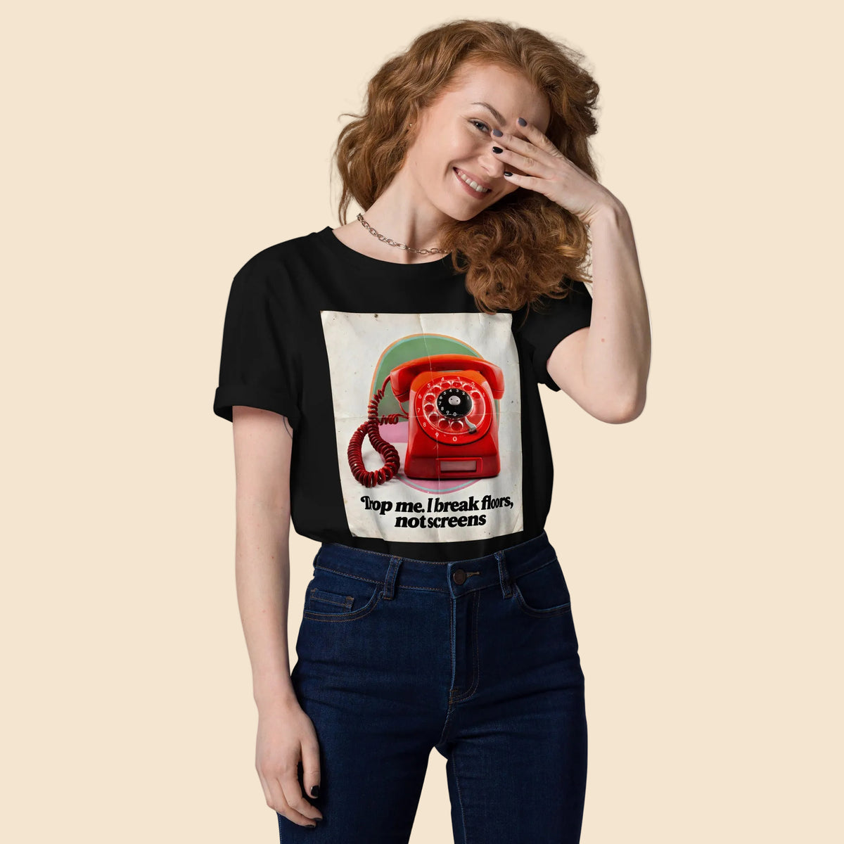 Chica vistiendo camiseta negra con gráfico pop de teléfono rojo de los años 70
