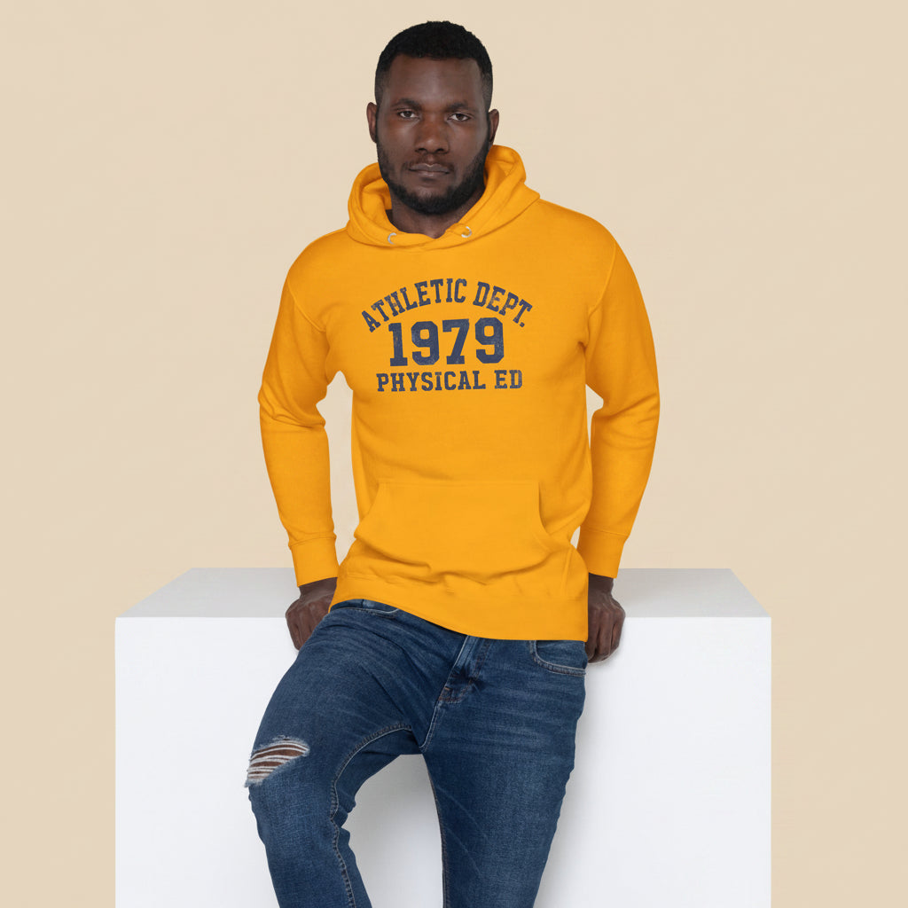 Hombre sentado vistiendo sudadera mostaza de estilo varsity clásico.
