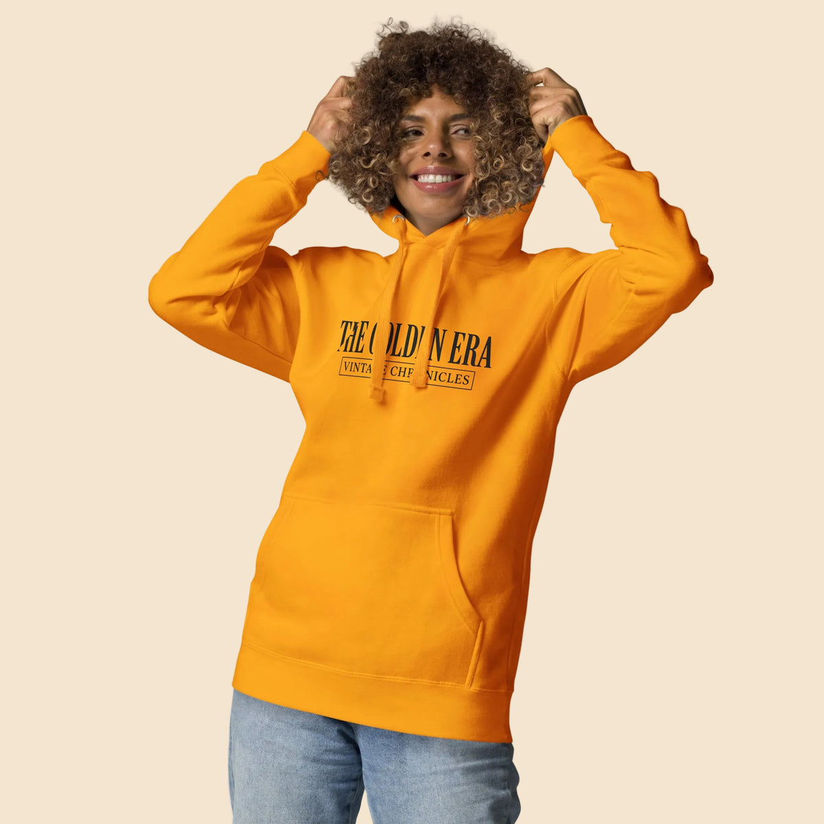 Mujer luciendo sudadera premium mostaza con tipografía vintage clásica.