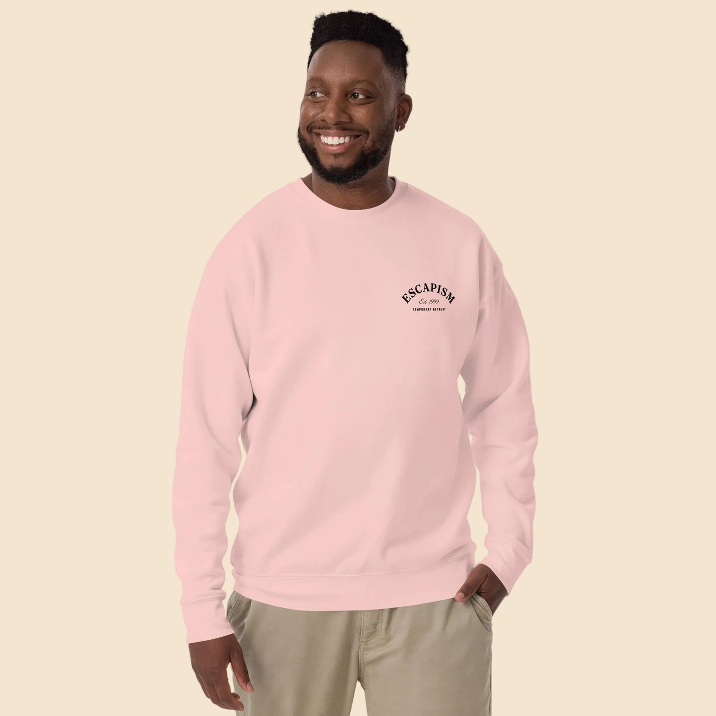 Hombre con sudadera premium rosa claro y diseño sutil en el pecho.
