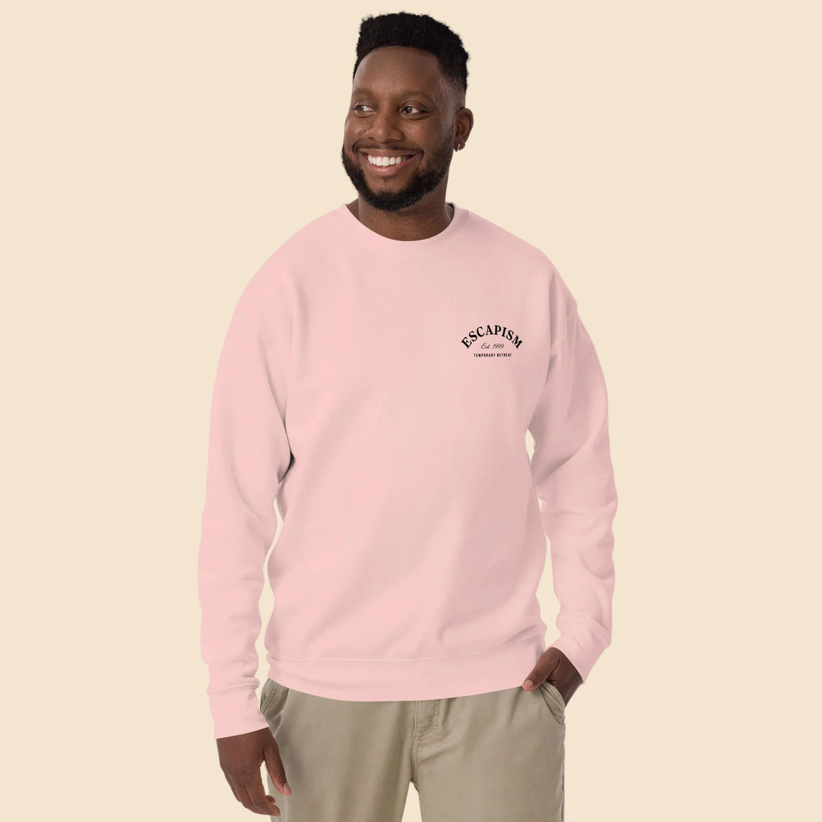 Hombre con sudadera premium rosa claro y diseño sutil en el pecho.